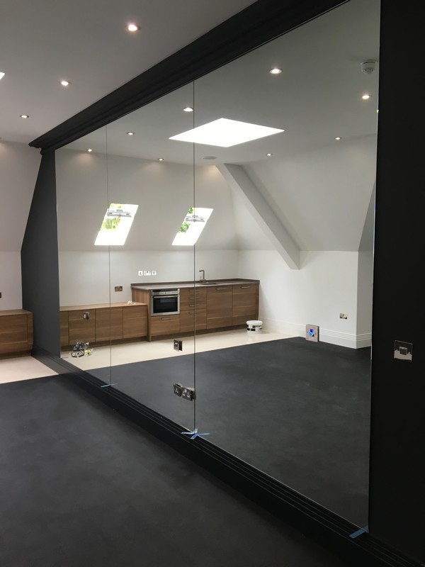Frameless glass partition in loft conversion by Dalston glaziers